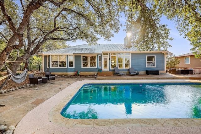 back of property featuring a pool side deck, an outdoor living space, and a patio