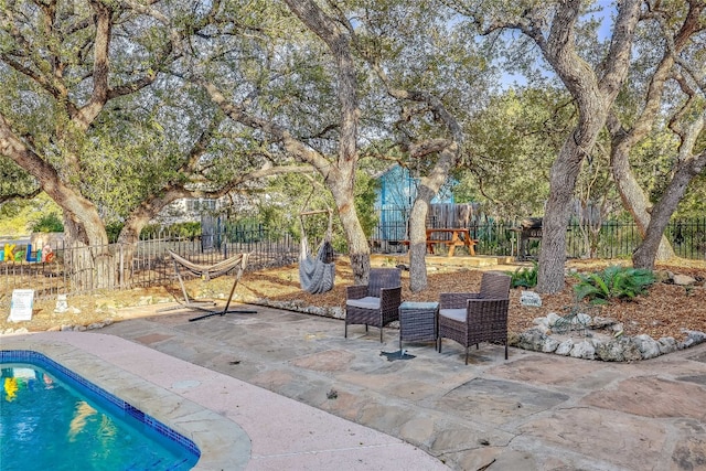 view of patio featuring a playground and a fenced in pool