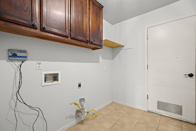 laundry room featuring hookup for a washing machine, cabinets, light tile patterned flooring, and electric dryer hookup