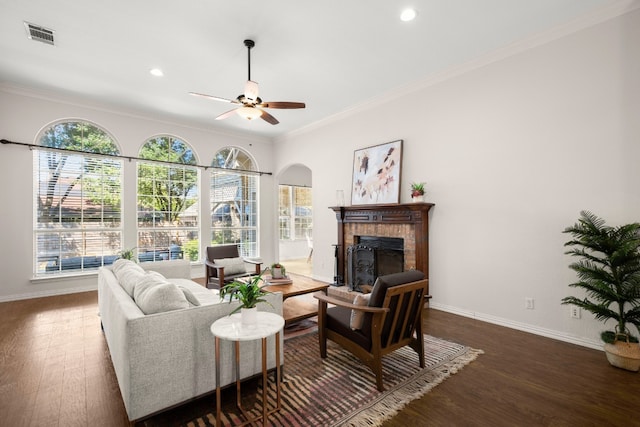 living room with dark wood-type flooring, a healthy amount of sunlight, and crown molding