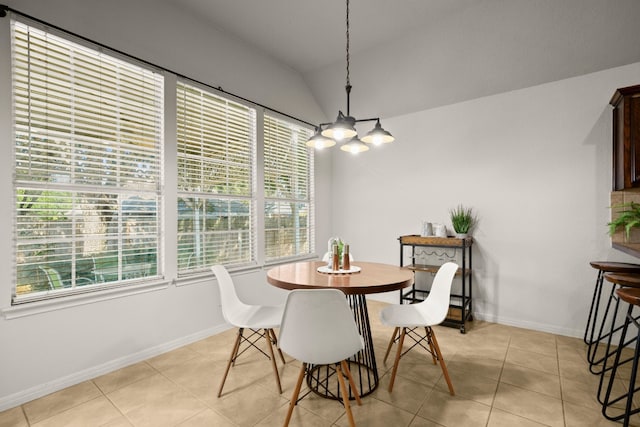 dining room featuring lofted ceiling, light tile patterned floors, and a notable chandelier