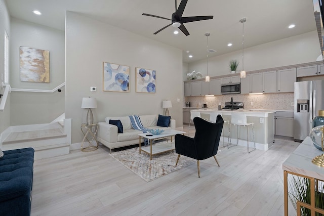 living room featuring light hardwood / wood-style flooring and ceiling fan