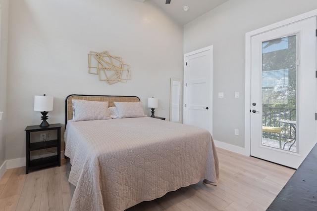 bedroom featuring lofted ceiling, light hardwood / wood-style flooring, and access to outside