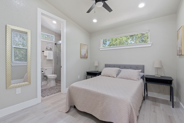 bedroom with lofted ceiling, connected bathroom, light hardwood / wood-style flooring, and ceiling fan