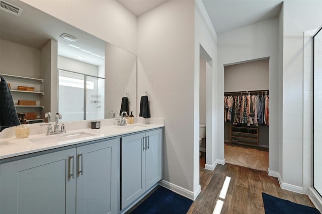 bathroom featuring walk in shower, vanity, toilet, and hardwood / wood-style flooring