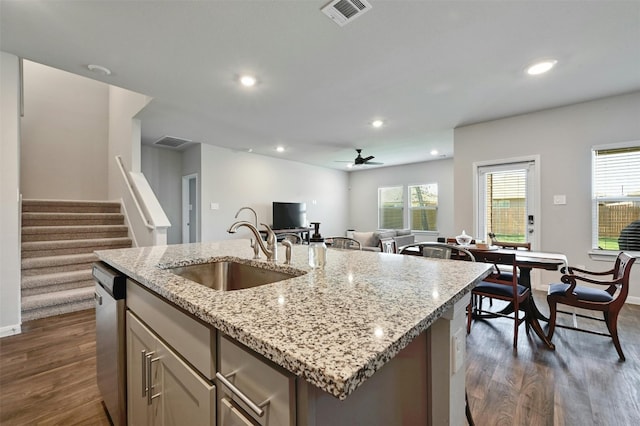 kitchen featuring a healthy amount of sunlight, a kitchen island with sink, sink, and dark hardwood / wood-style flooring