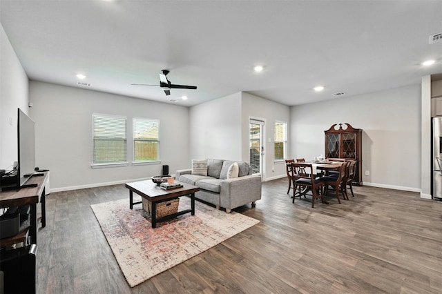 living room with dark hardwood / wood-style flooring and ceiling fan