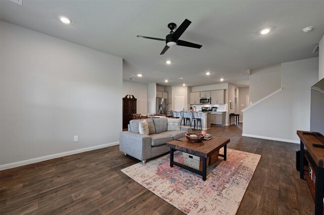 living room with ceiling fan and dark hardwood / wood-style floors