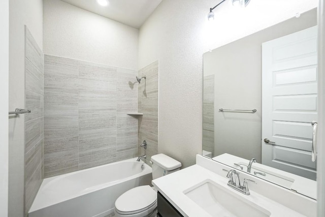 full bathroom featuring tiled shower / bath, vanity, and toilet