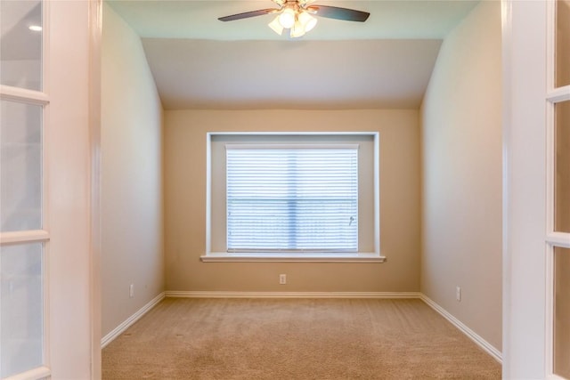 carpeted spare room featuring ceiling fan and lofted ceiling