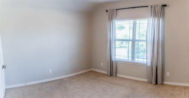 unfurnished room with lofted ceiling and light carpet