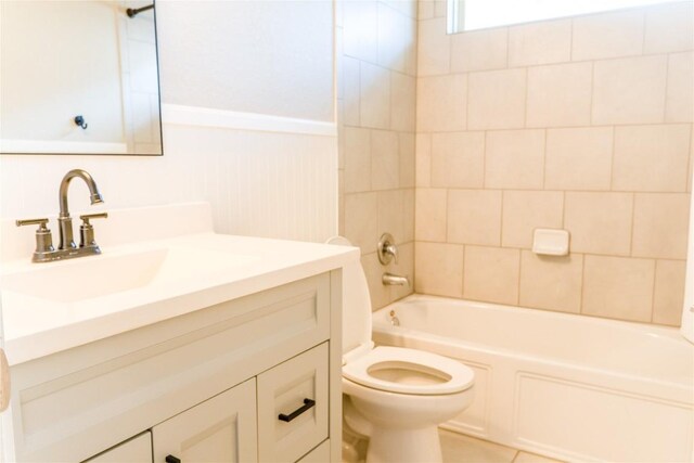 full bathroom featuring toilet, vanity, and tiled shower / bath