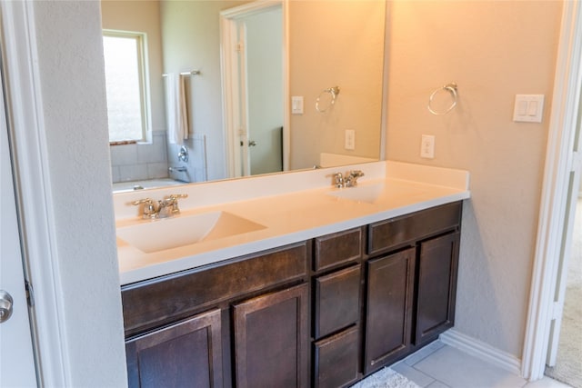 bathroom featuring tile patterned flooring, a bath, and vanity