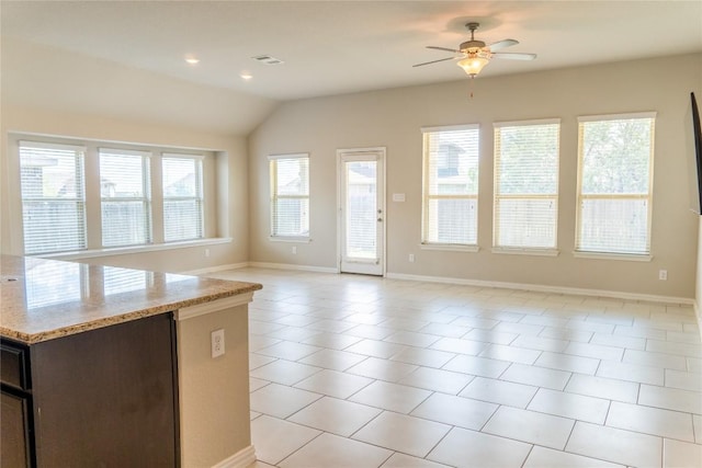 kitchen featuring light stone countertops, light tile patterned floors, lofted ceiling, and ceiling fan