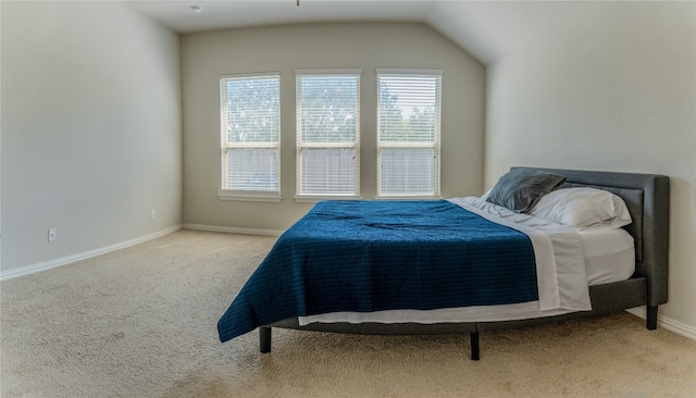 carpeted bedroom with lofted ceiling