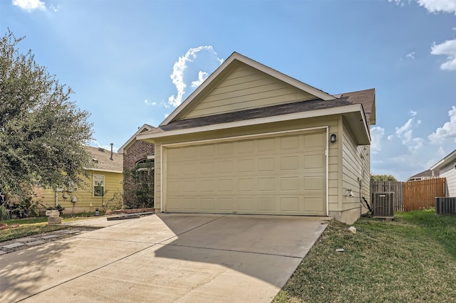 view of front of property featuring a garage, central AC, and a front lawn