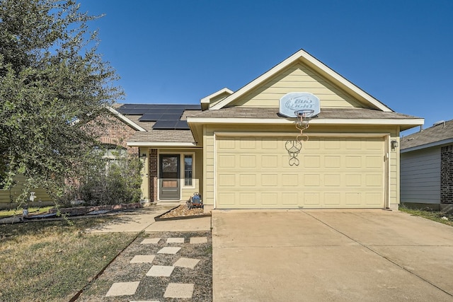 ranch-style house with a garage and solar panels