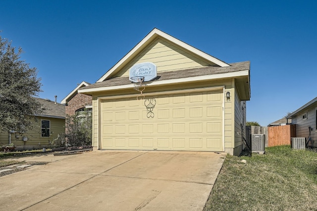 view of front of house with cooling unit, a garage, and a front lawn