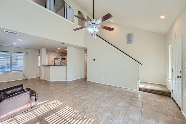 unfurnished living room featuring high vaulted ceiling, ceiling fan, and light tile patterned floors