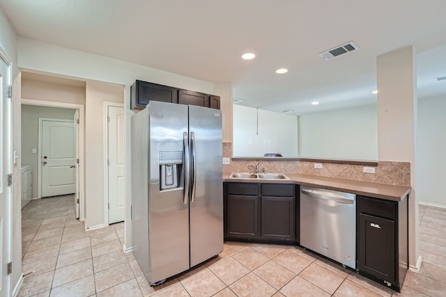 kitchen with light tile patterned floors, stainless steel appliances, sink, and tasteful backsplash