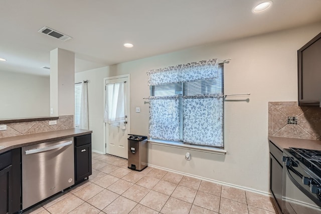 kitchen with appliances with stainless steel finishes, backsplash, and light tile patterned floors