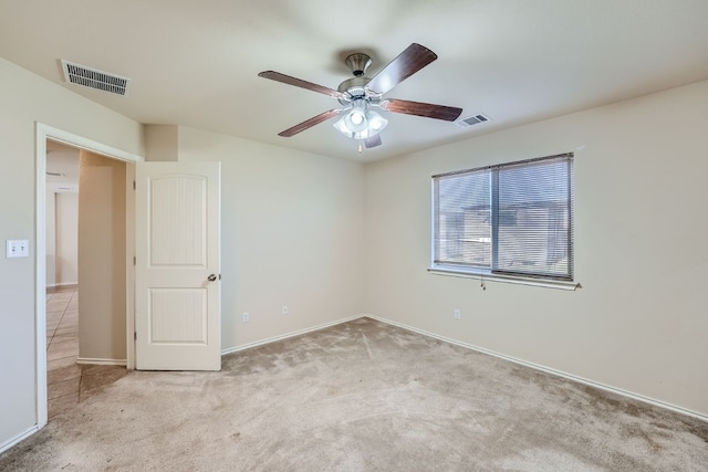 spare room featuring light carpet and ceiling fan