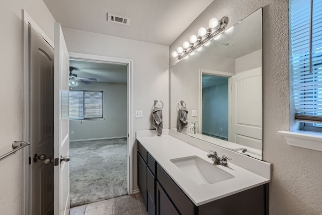 bathroom featuring ceiling fan, vanity, and a textured ceiling