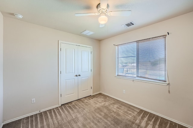 unfurnished bedroom with a closet, ceiling fan, and carpet flooring