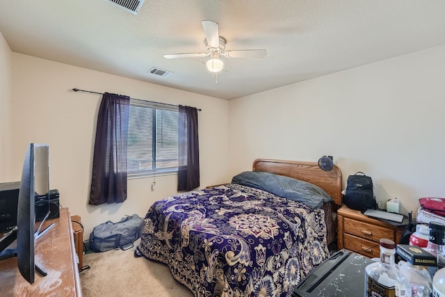 carpeted bedroom with ceiling fan and a textured ceiling