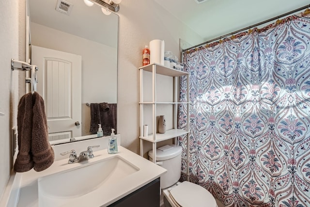 bathroom featuring walk in shower, vanity, and toilet