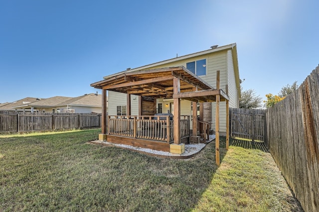 rear view of property featuring a lawn and a deck