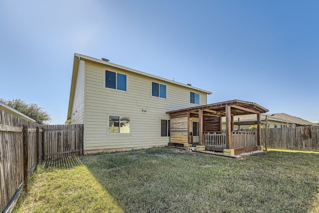 rear view of house featuring a wooden deck and a yard