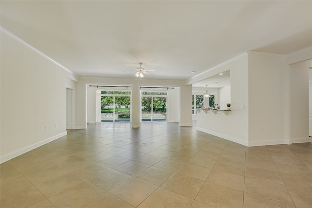 tiled empty room with ornamental molding and ceiling fan