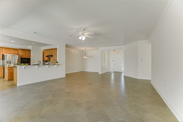 unfurnished living room with ceiling fan with notable chandelier and light tile patterned flooring