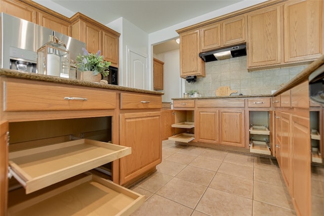 kitchen with light stone counters, light tile patterned flooring, and tasteful backsplash