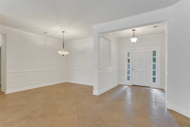 tiled entrance foyer featuring ornamental molding and ornate columns