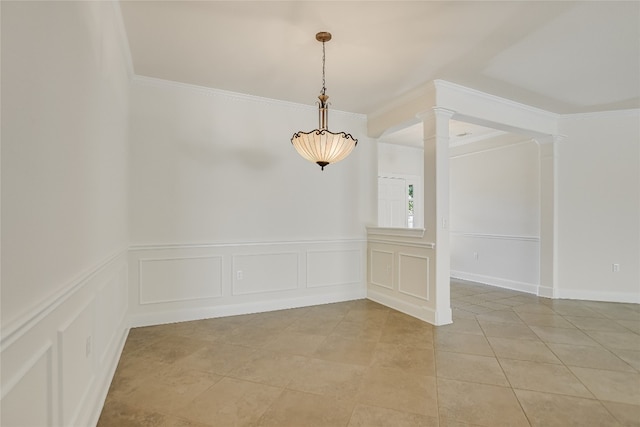 tiled empty room with ornamental molding and decorative columns