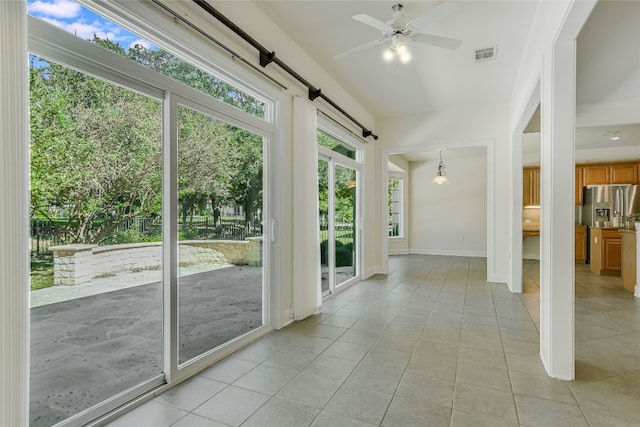 unfurnished sunroom featuring ceiling fan