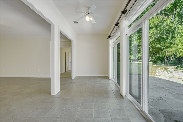 unfurnished sunroom featuring ceiling fan