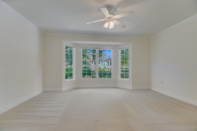 spare room featuring ceiling fan, light colored carpet, and crown molding