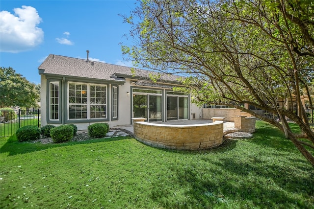 back of house featuring a lawn and a patio