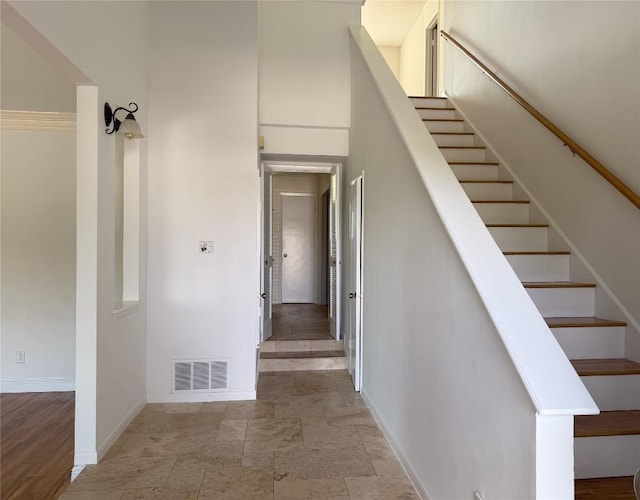 stairway featuring a towering ceiling