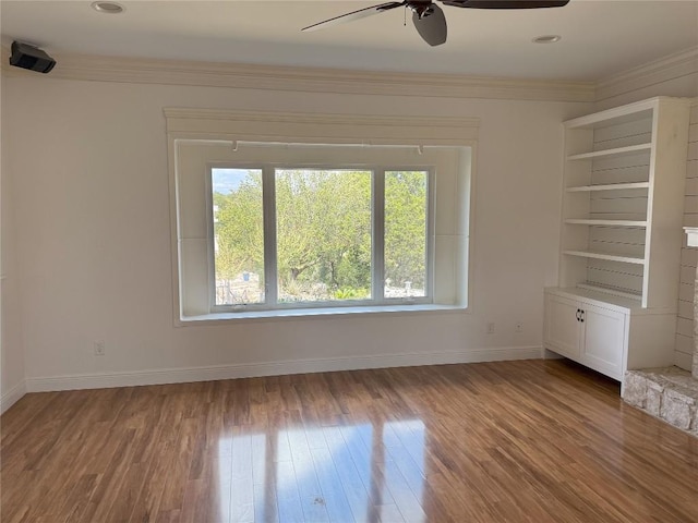 spare room featuring hardwood / wood-style flooring, ornamental molding, and ceiling fan