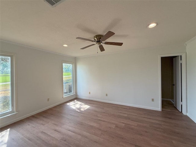 empty room with ornamental molding, ceiling fan, and light wood-type flooring