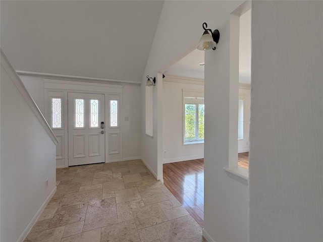 foyer with light wood-type flooring and vaulted ceiling