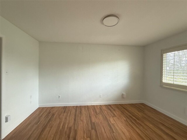 spare room with dark hardwood / wood-style flooring