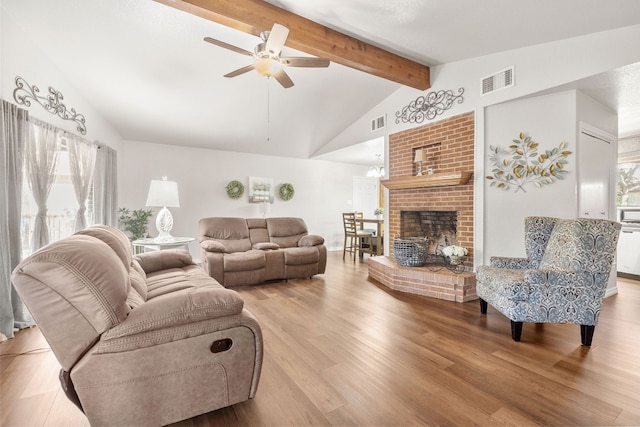 living room with beam ceiling, light wood-type flooring, ceiling fan, and a healthy amount of sunlight