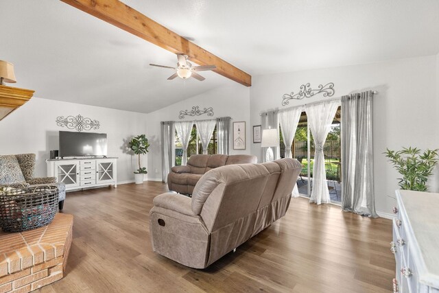 living room featuring plenty of natural light, lofted ceiling with beams, and hardwood / wood-style flooring