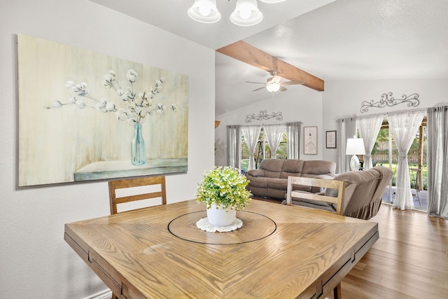 dining space with vaulted ceiling with beams, plenty of natural light, ceiling fan, and wood-type flooring