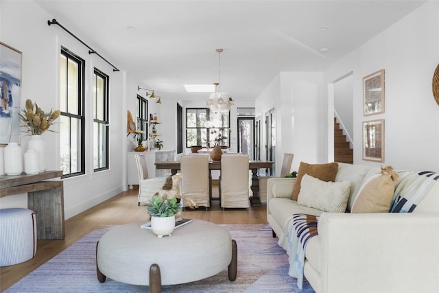 living room featuring wood-type flooring and a chandelier